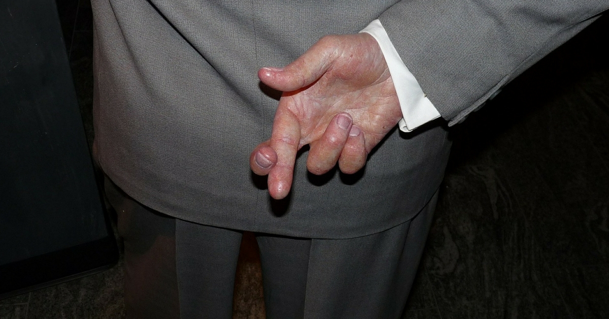 Man with deceptive fingers crossed