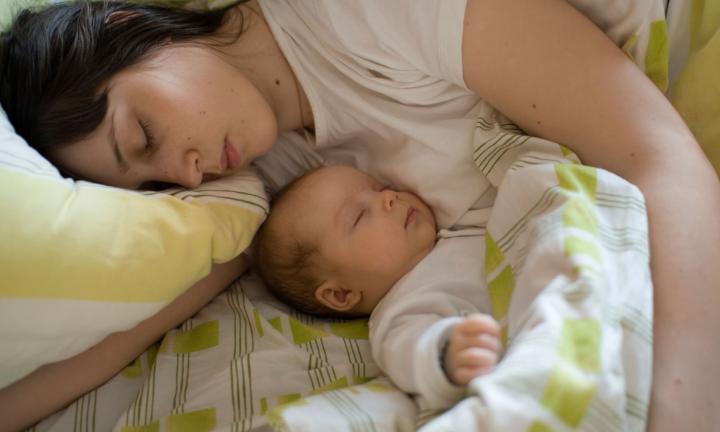 mother sleeping with her newborn baby