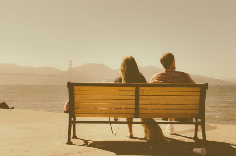 couple sitting on bench resolving conflict in marriage