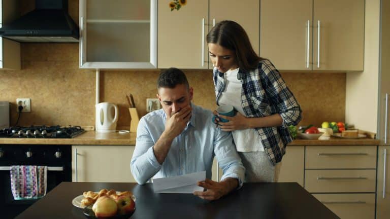 Couple looking stressed over bills at the kitchen table