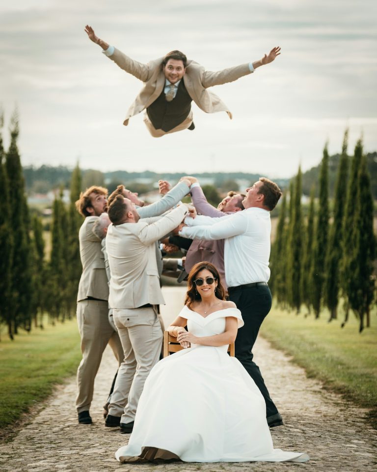 Wedding guests lifting each other up in a fun group celebration photo