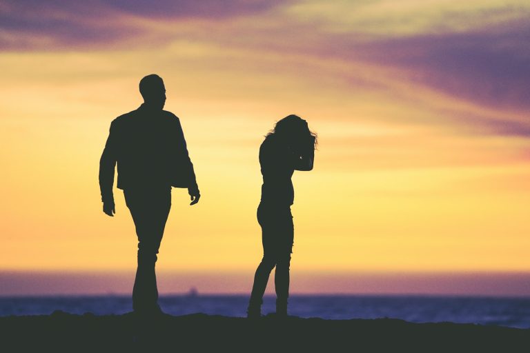 Silhouette of a man and woman under a yellow light