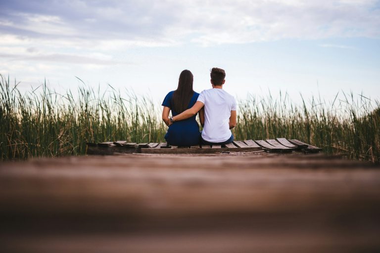 Husband and wife sitting together on a wooden bench