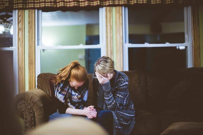 Couple in sweaters sitting close together on a couch