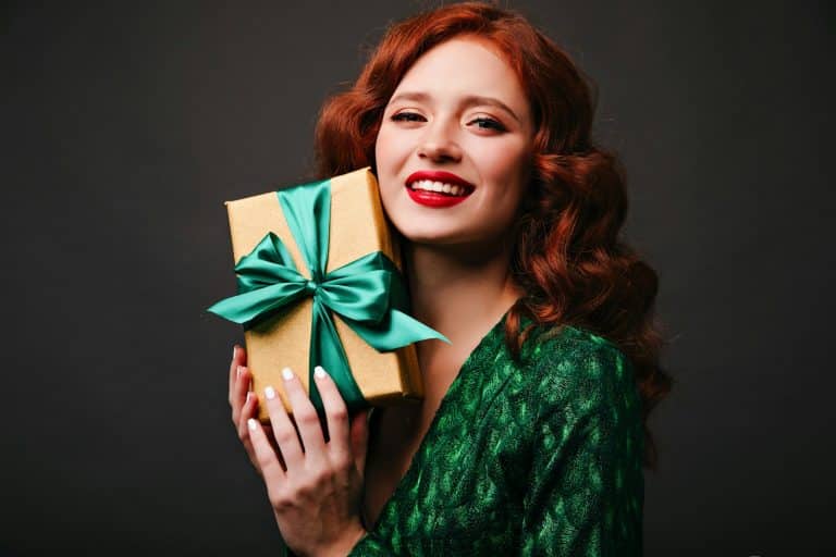 Woman holding a Christmas present with a green bow