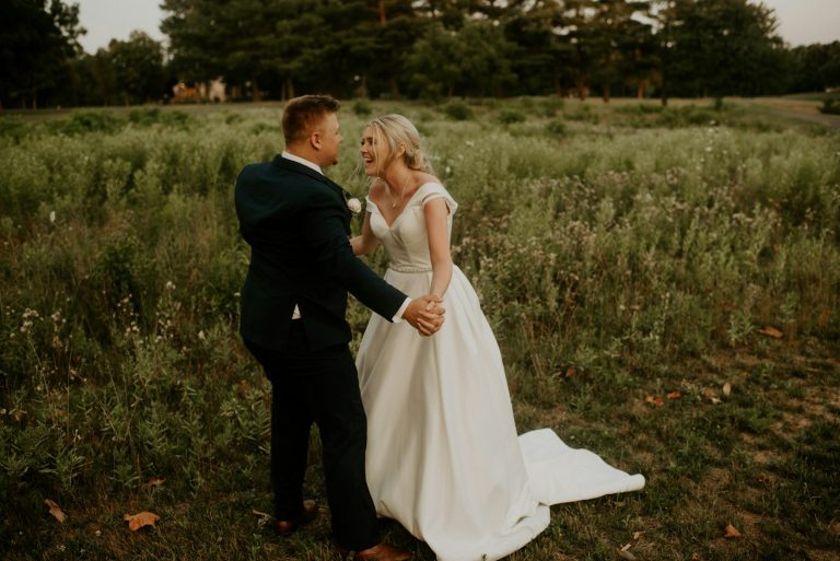 Groom in a black suit kissing his bride