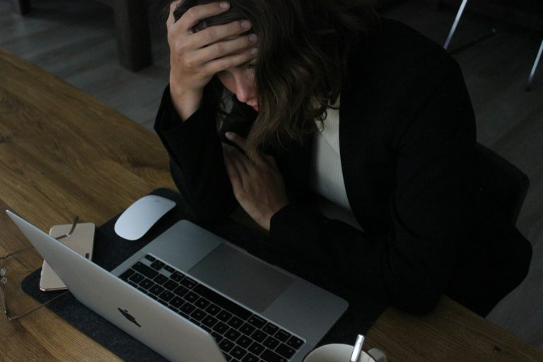 Stressed woman with her head in her hands