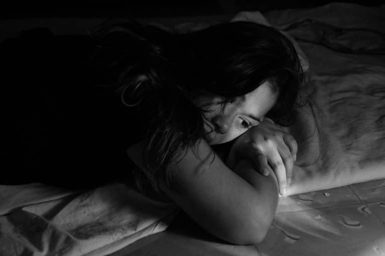 Upset woman leaning on the bed