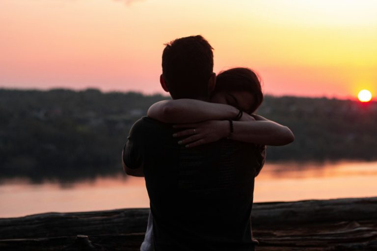Couple hugging at sunset