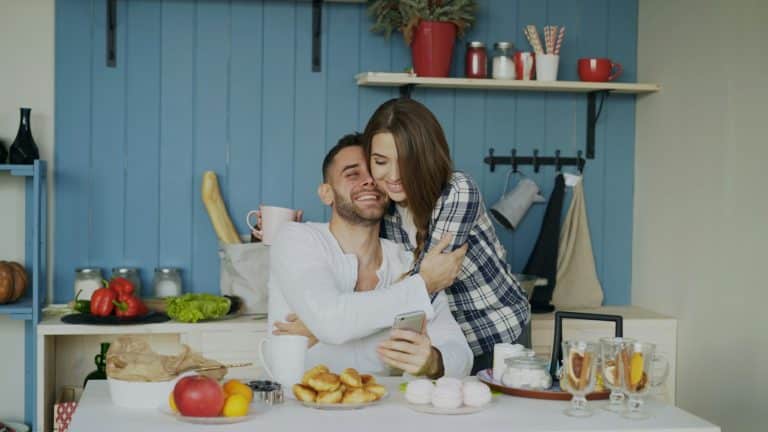 Couple hugging and smiling in their kitchen