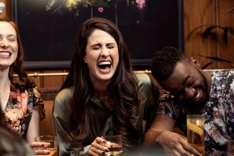 Couple laughing with friends around a table