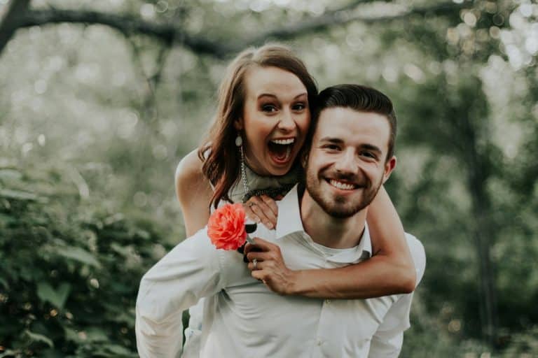 Wife laughing while riding piggyback on her husband