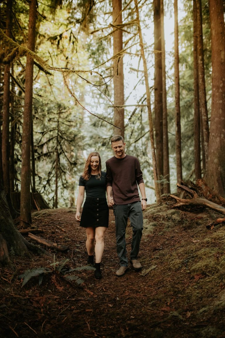Couple walking through a forest holding hands