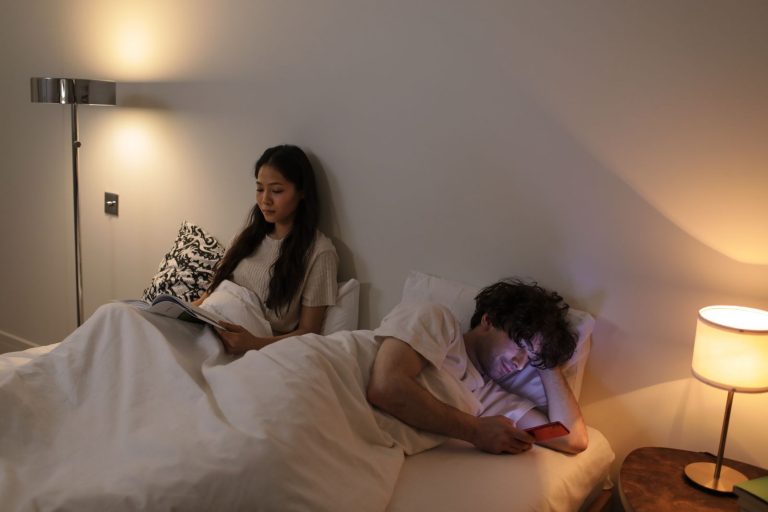 Couple in bed, one asleep and one still awake